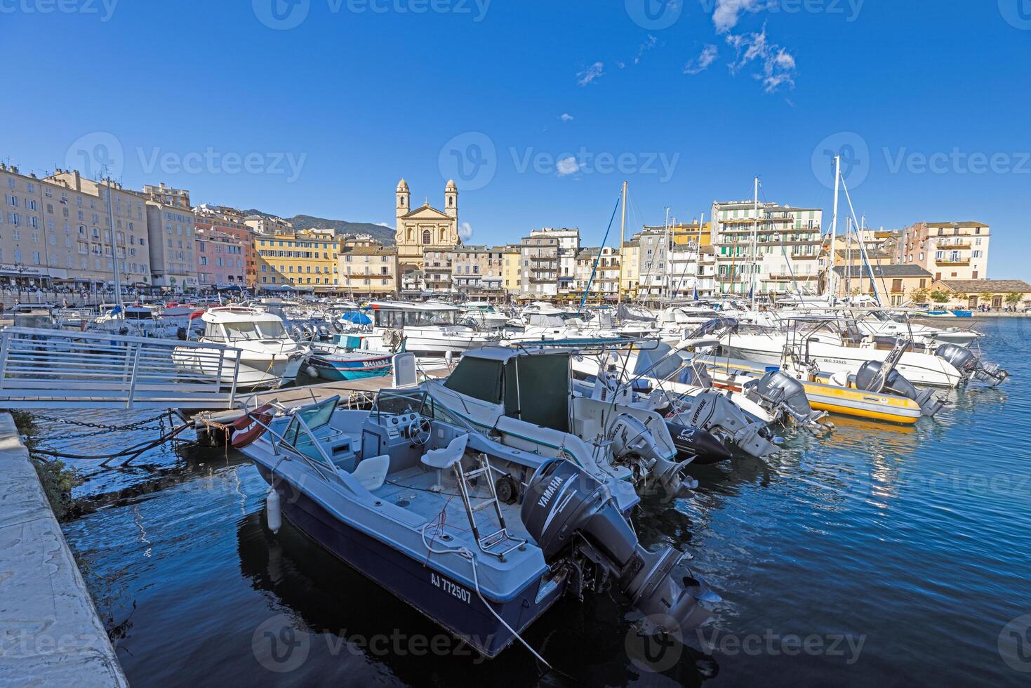 Scenic view of Bastia harbor and historic promenade with colorful buildings under a clear blue sky photo