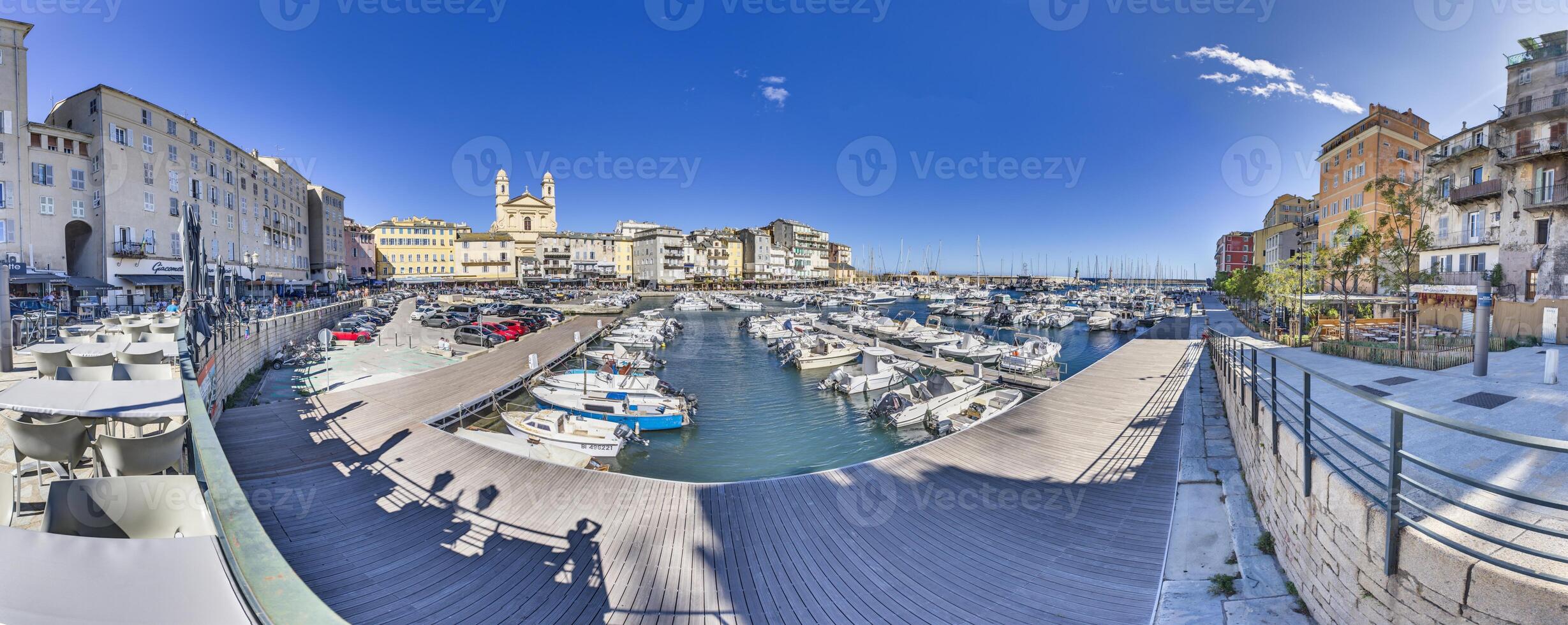 Scenic view of Bastia harbor and historic promenade with colorful buildings under a clear blue sky photo