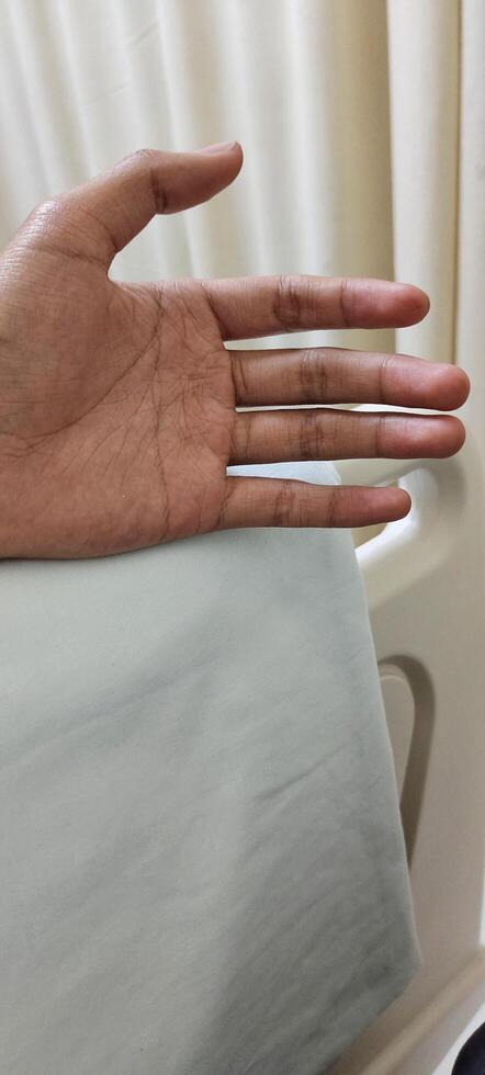 Portrait of a man hand lying in a hospital patient's room photo
