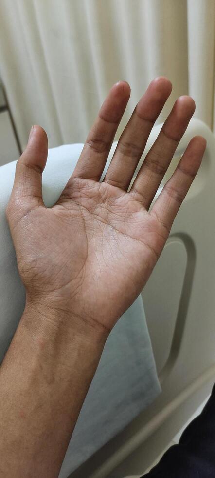 Portrait of a man hand lying in a hospital patient's room photo