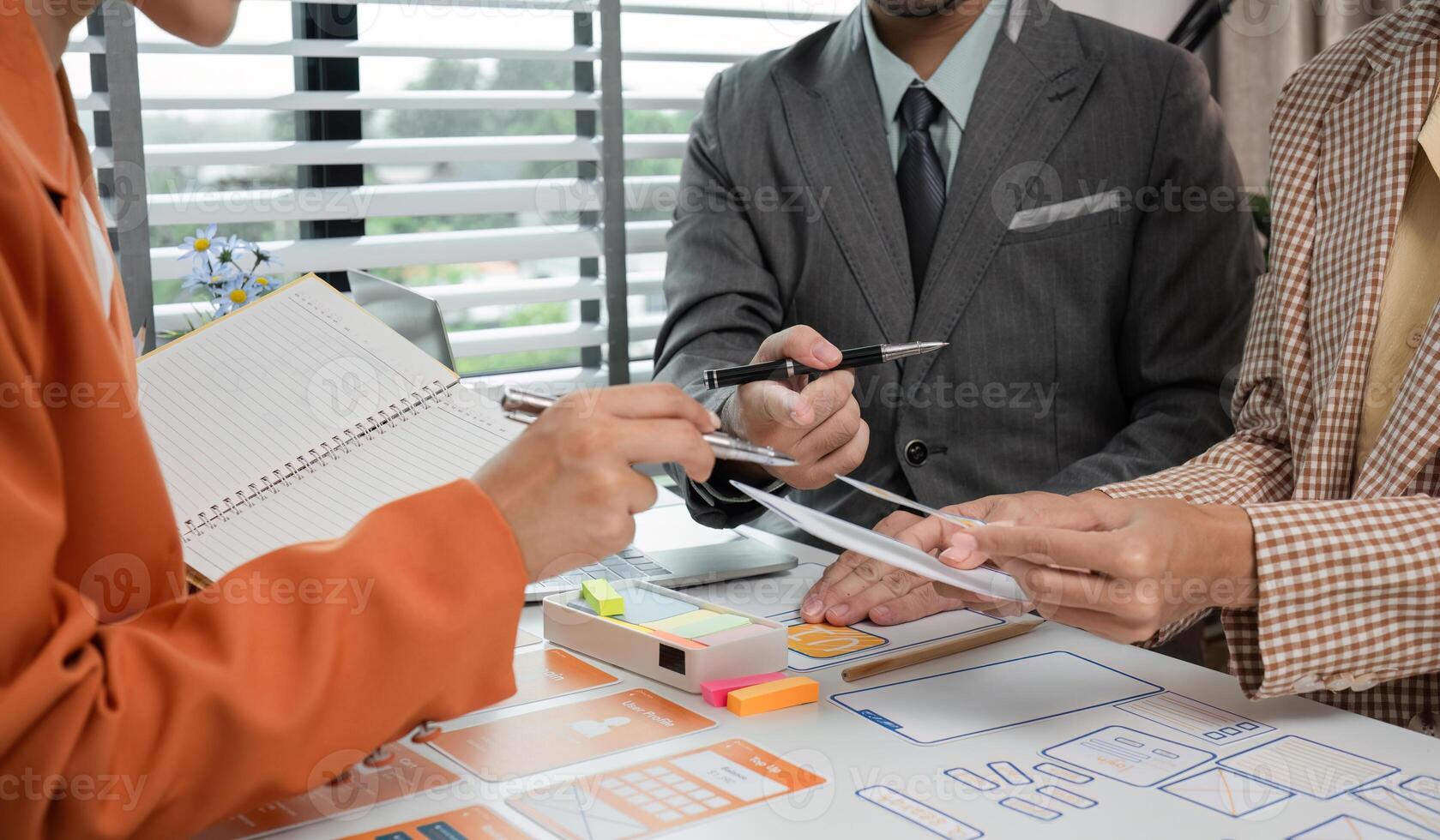 Creative Team Collaborates on UX UI Design Project in Modern Office Setting with Digital and Paper Prototypes photo