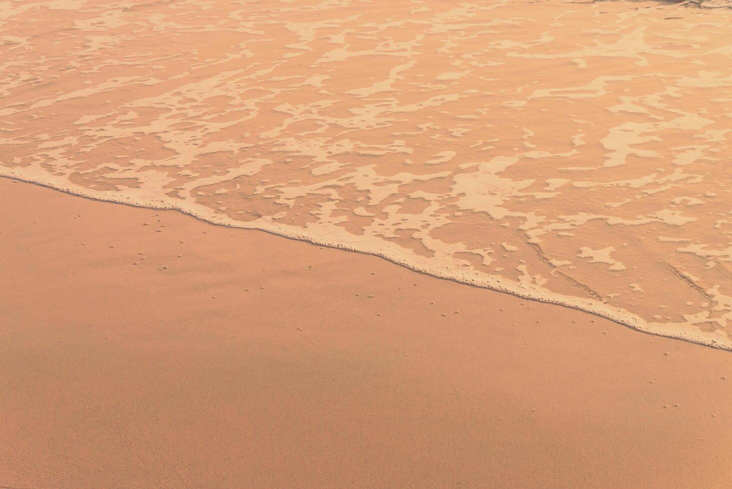 A person walking on the beach with a surfboard photo