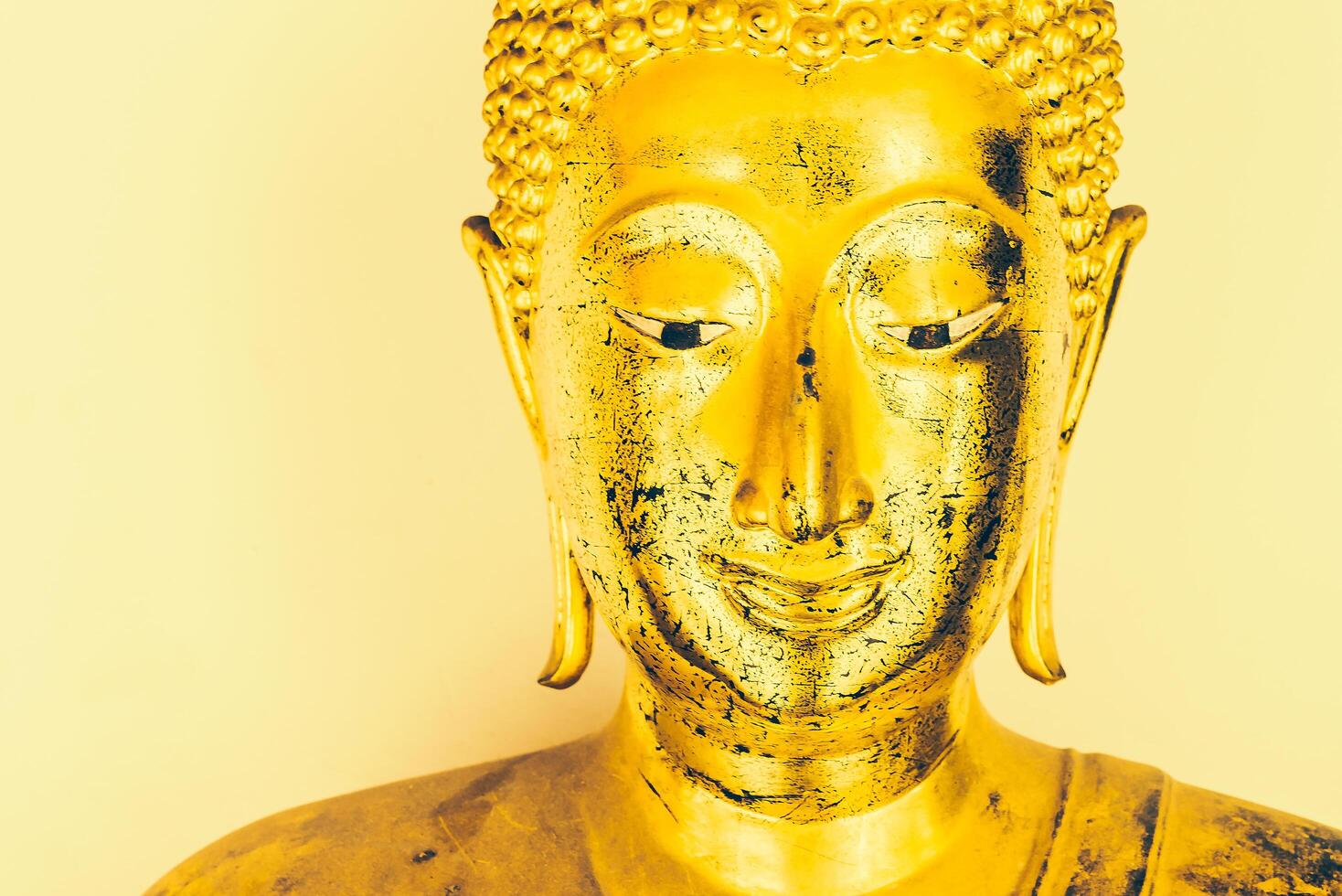 A golden buddha statue with a yellow background photo