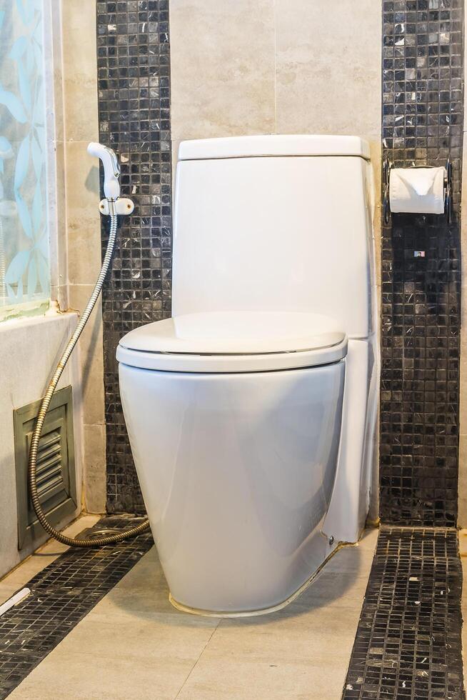 A white toilet sitting in a bathroom with a shower photo