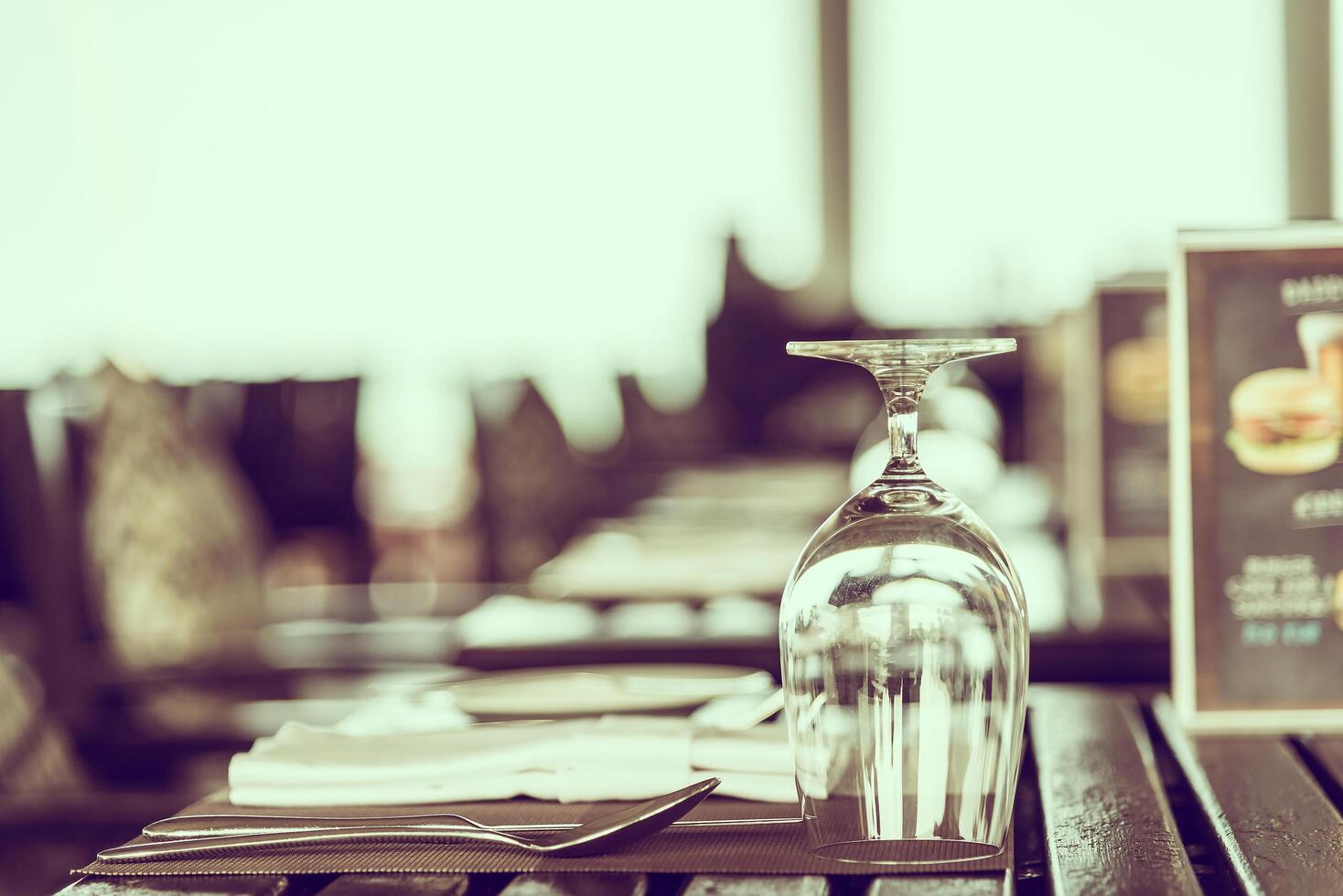 A table with a glass of wine and a menu photo