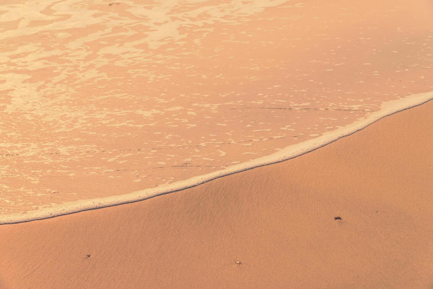 A person walking on the beach with a surfboard photo