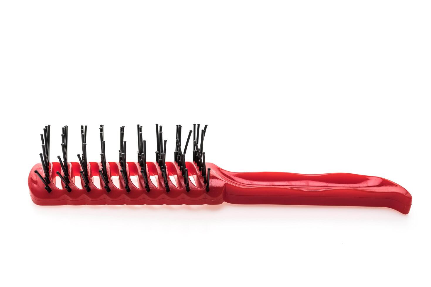 A red comb with black bristles on a white background photo