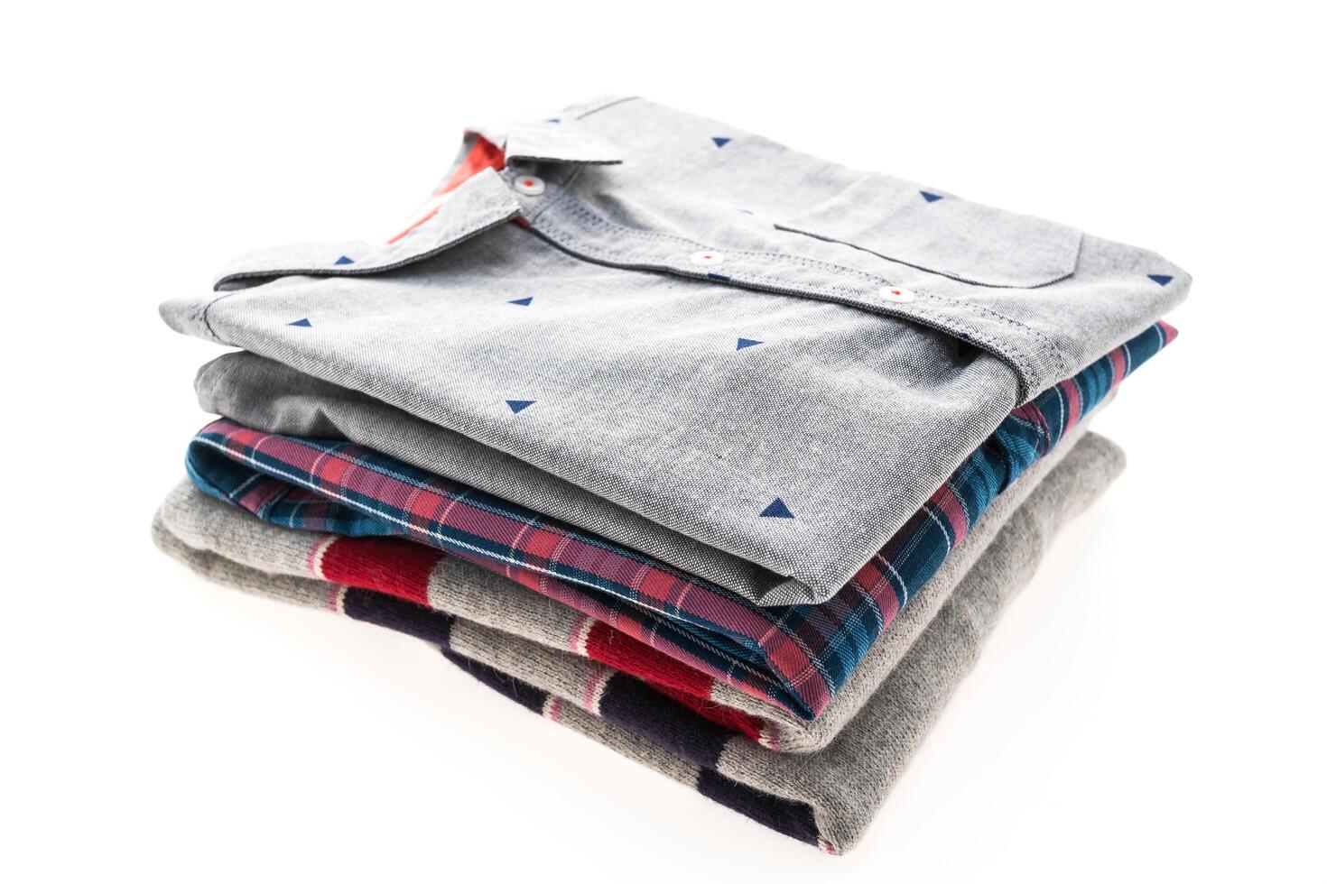 A stack of four shirts on a white background photo