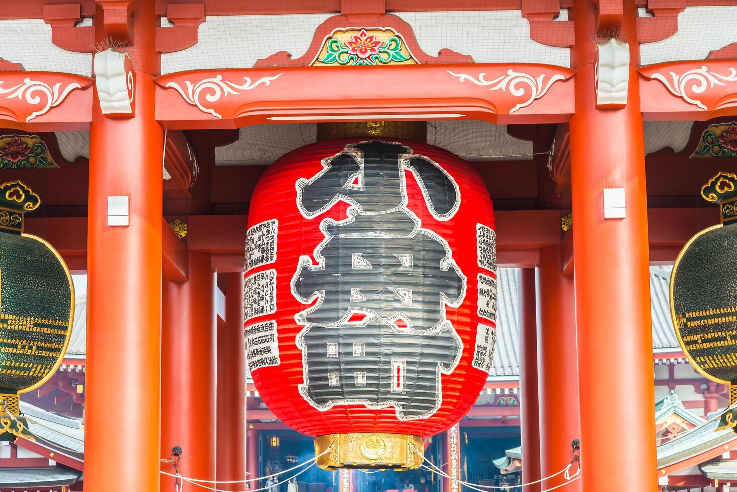 A large red lantern hanging from the ceiling of an asian building photo