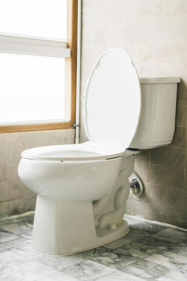 A white toilet sitting next to a window photo