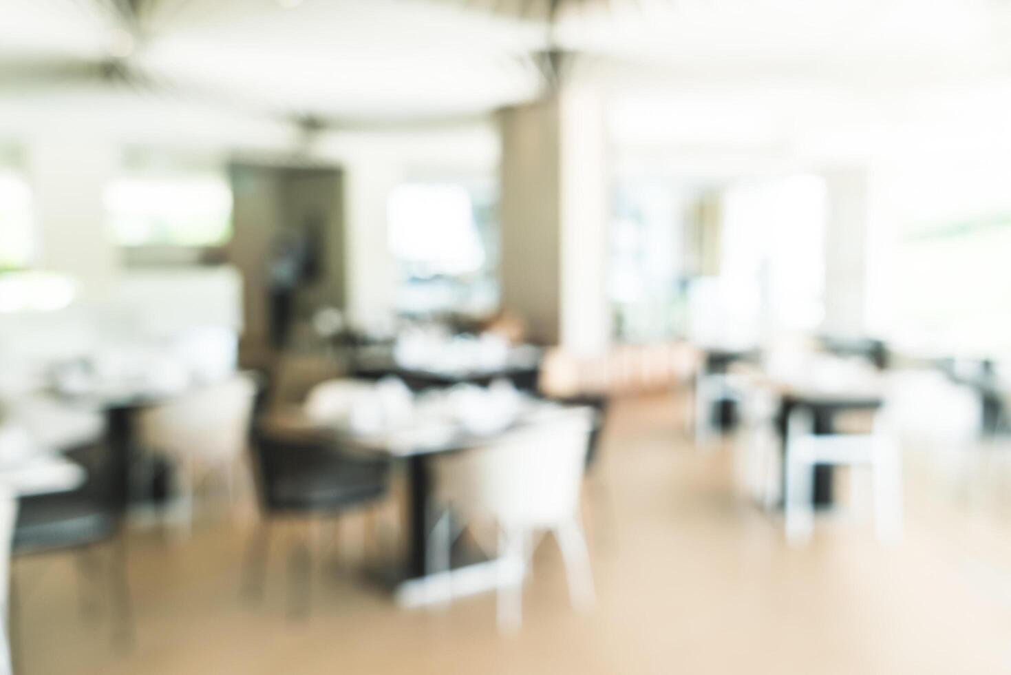 A blurry image of a restaurant with tables and chairs photo