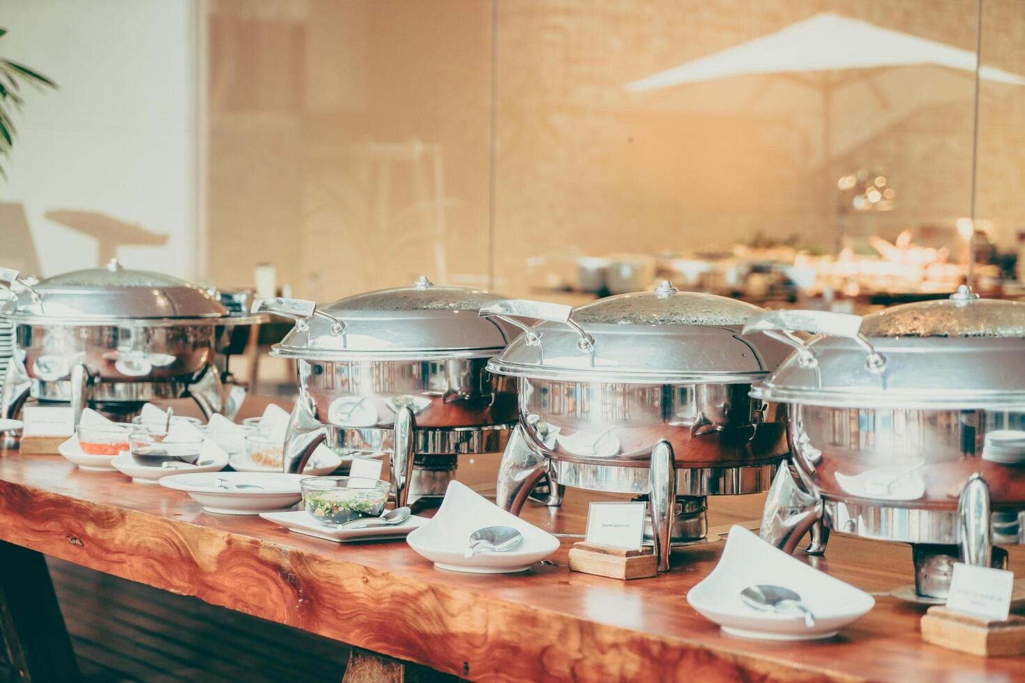 Buffet with silver trays and bowls on wooden table photo