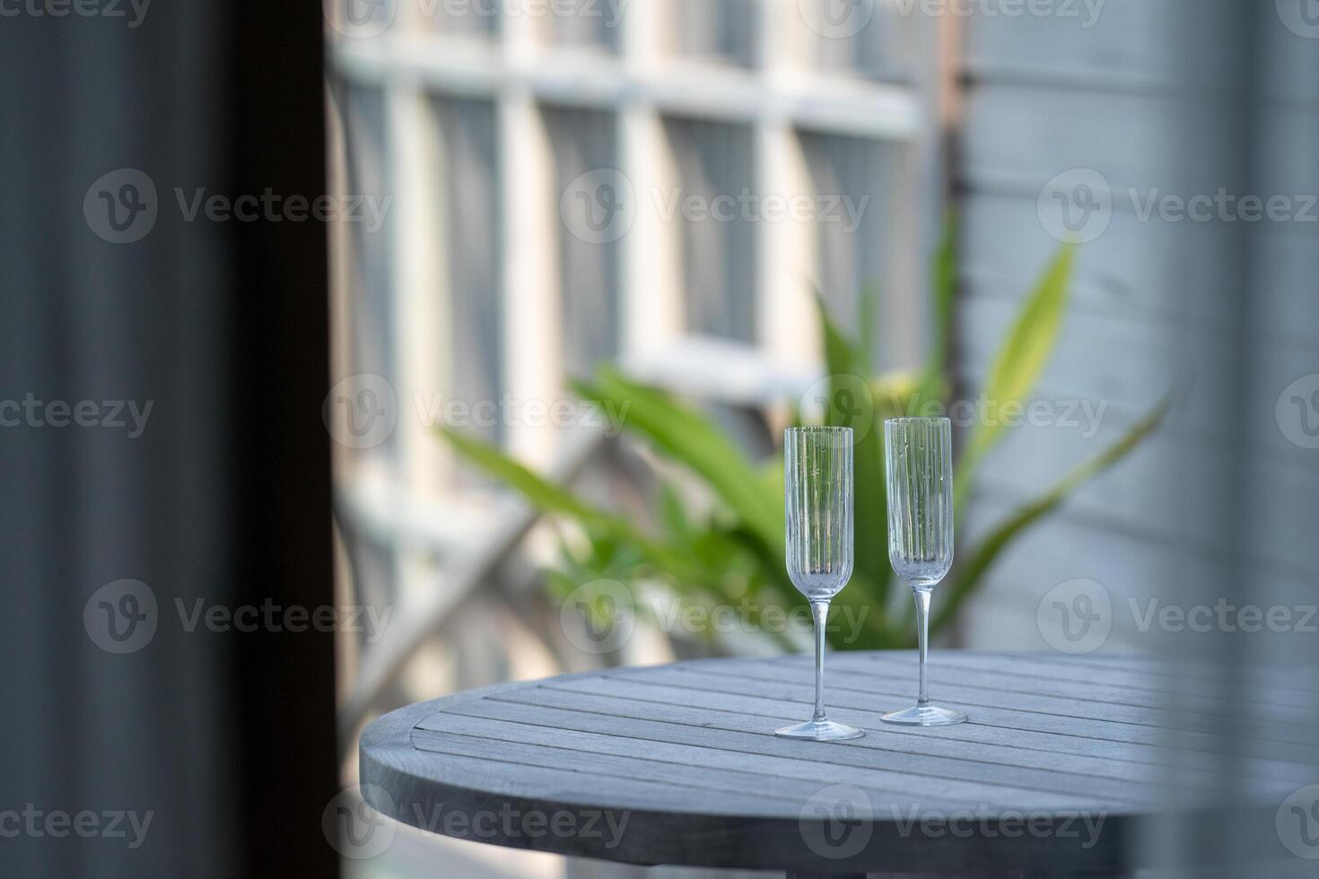 Champagne setting. Empty glasses with and tropical background. photo