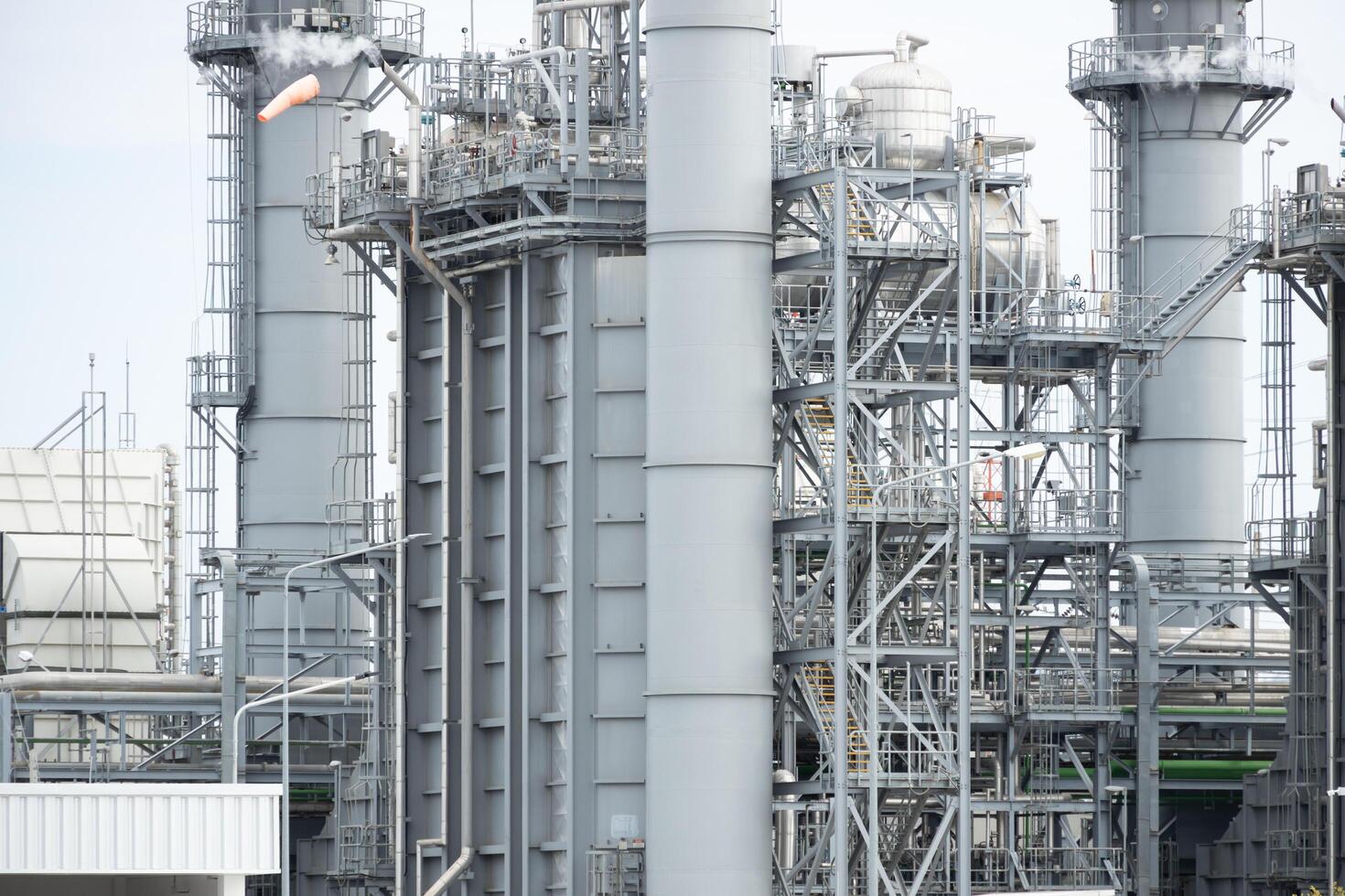 Oil petroleum refinery plant building distillation columns tower, Closeup part of fuel gas pipe complex, Crude oil petrochemical industrial building. photo