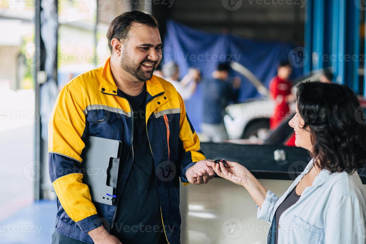 Customer women happy giving car key to mechanic worker for car service fix problem auto center workshop center photo