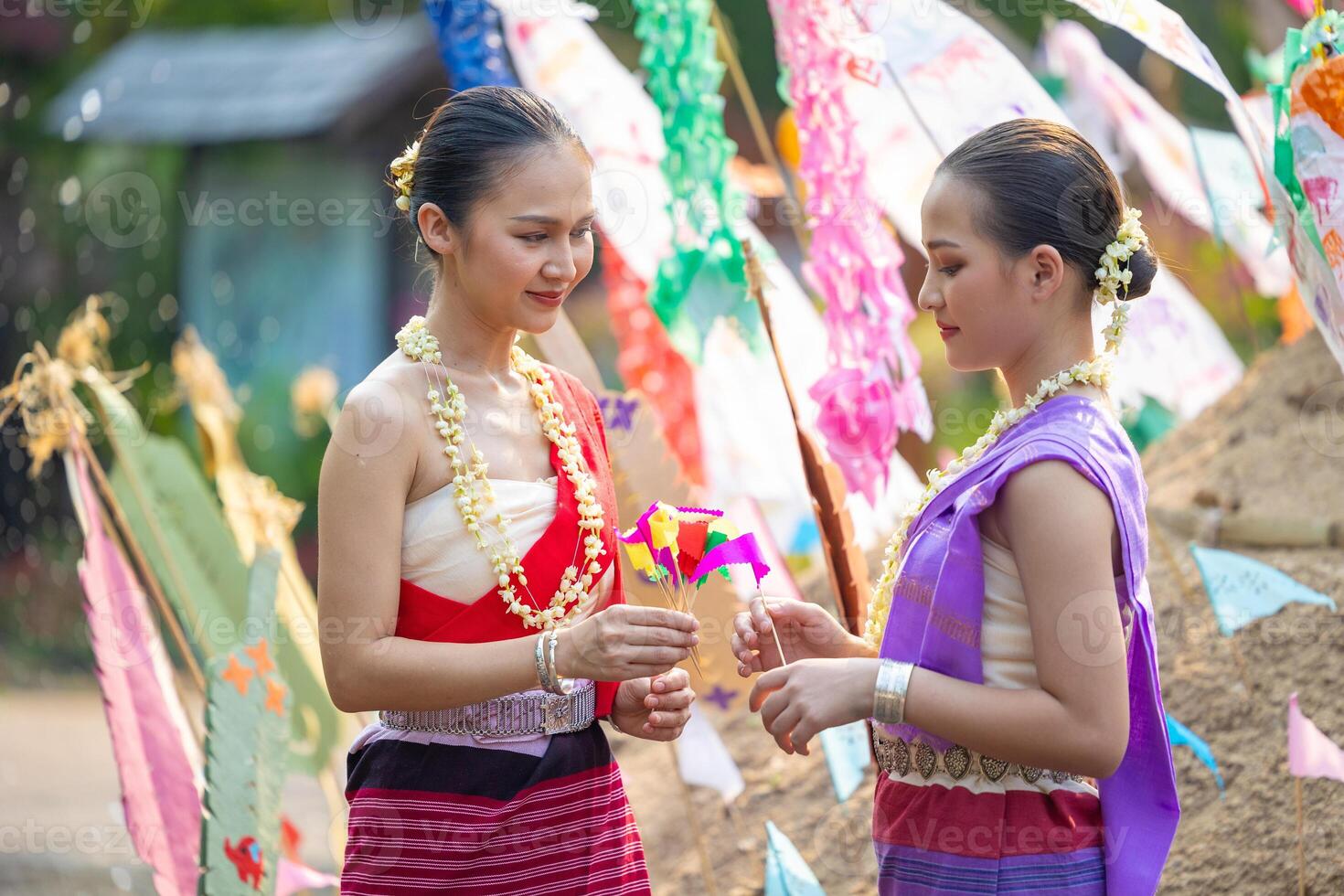 Songkran festival. Northern Thai people in Traditional clothes dressing carrying sand into temple to build sand pagoda and decoration with colorful paper flag. photo