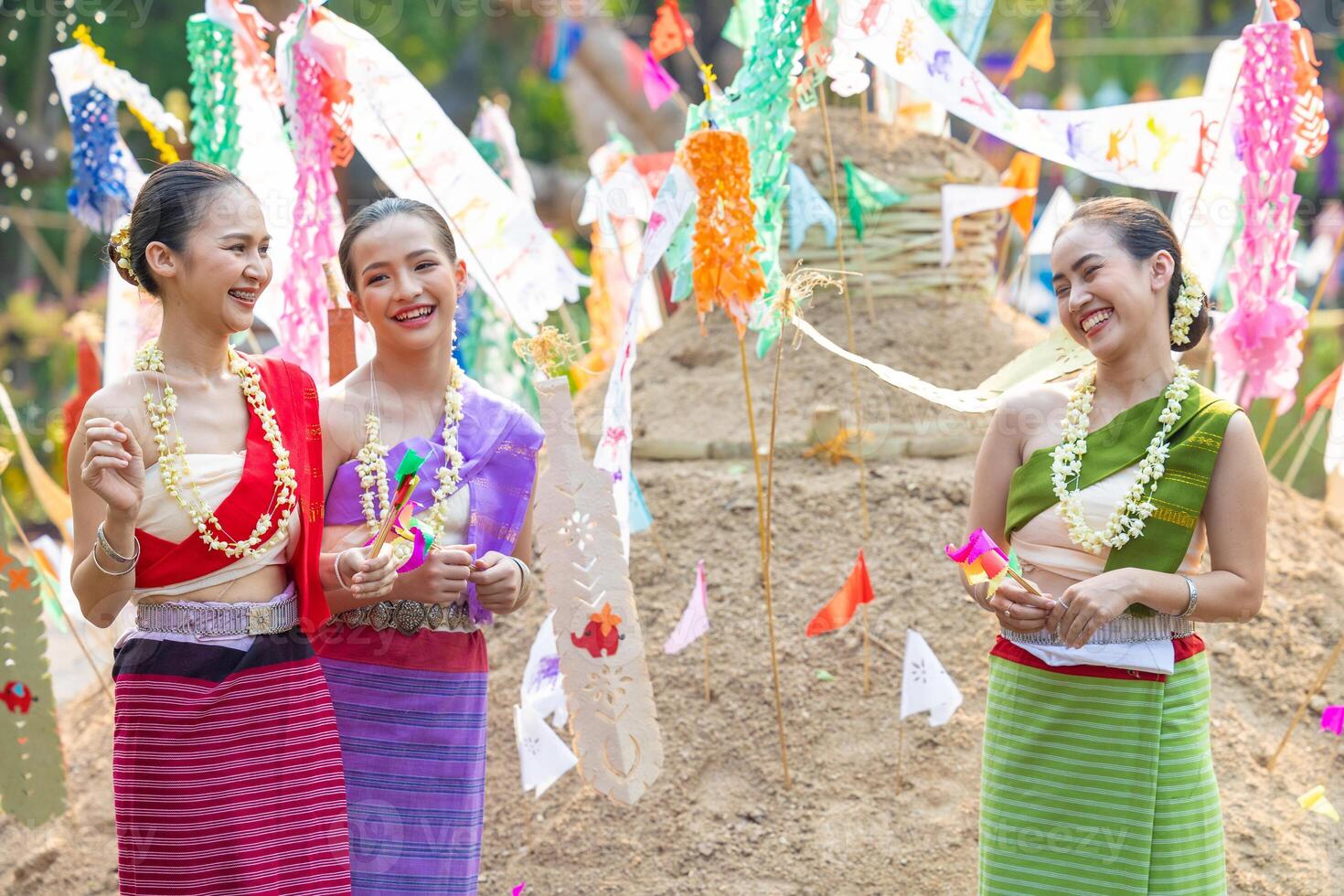 Songkran festival. Northern Thai people in Traditional clothes dressing carrying sand into temple to build sand pagoda and decoration with colorful paper flag. photo