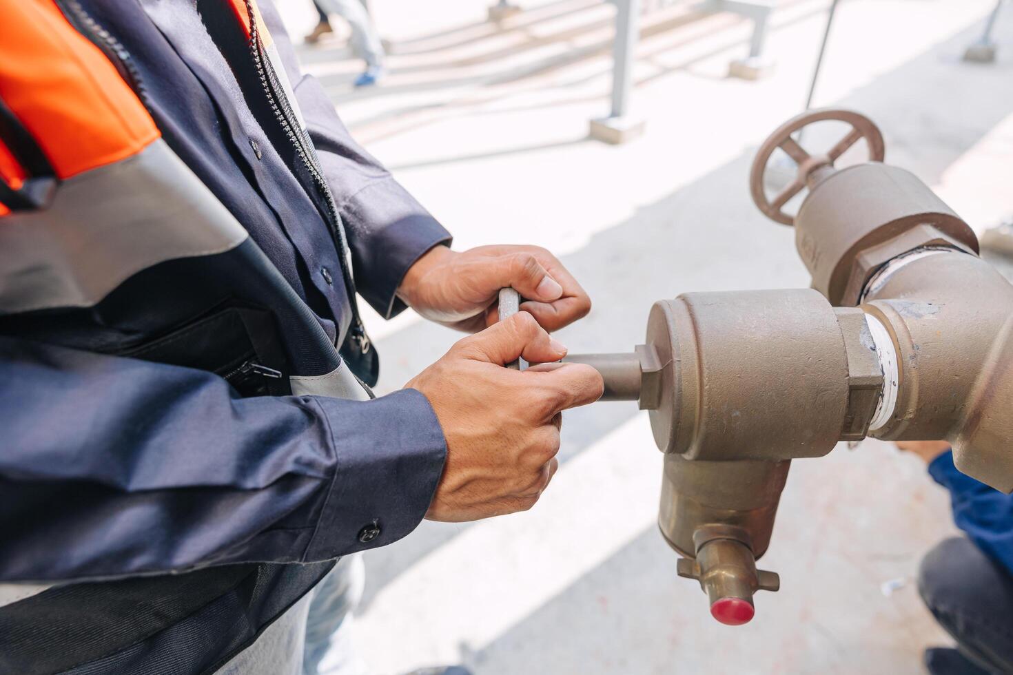 engineer man wearing a safety vest is working on a pipe valve to turn on off water pipe photo