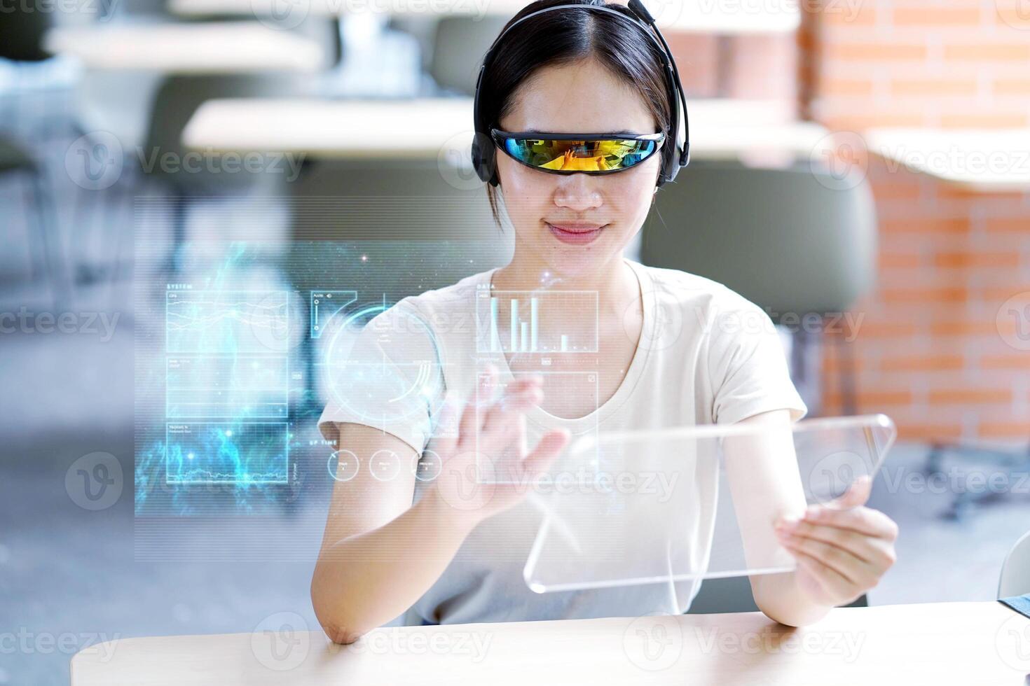 Closeup Asian female portrait holding and used transparence tablet computer working with lit by engineer HUD interface. GUI and Future technology concepts. photo