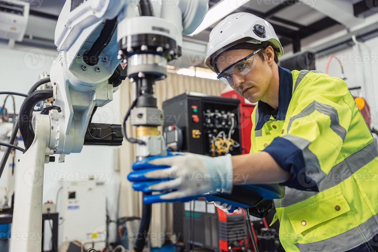 Engineer young man university student learn to control operate industry robot welding arm in robotics engineers lab classroom in polytechnic education. photo