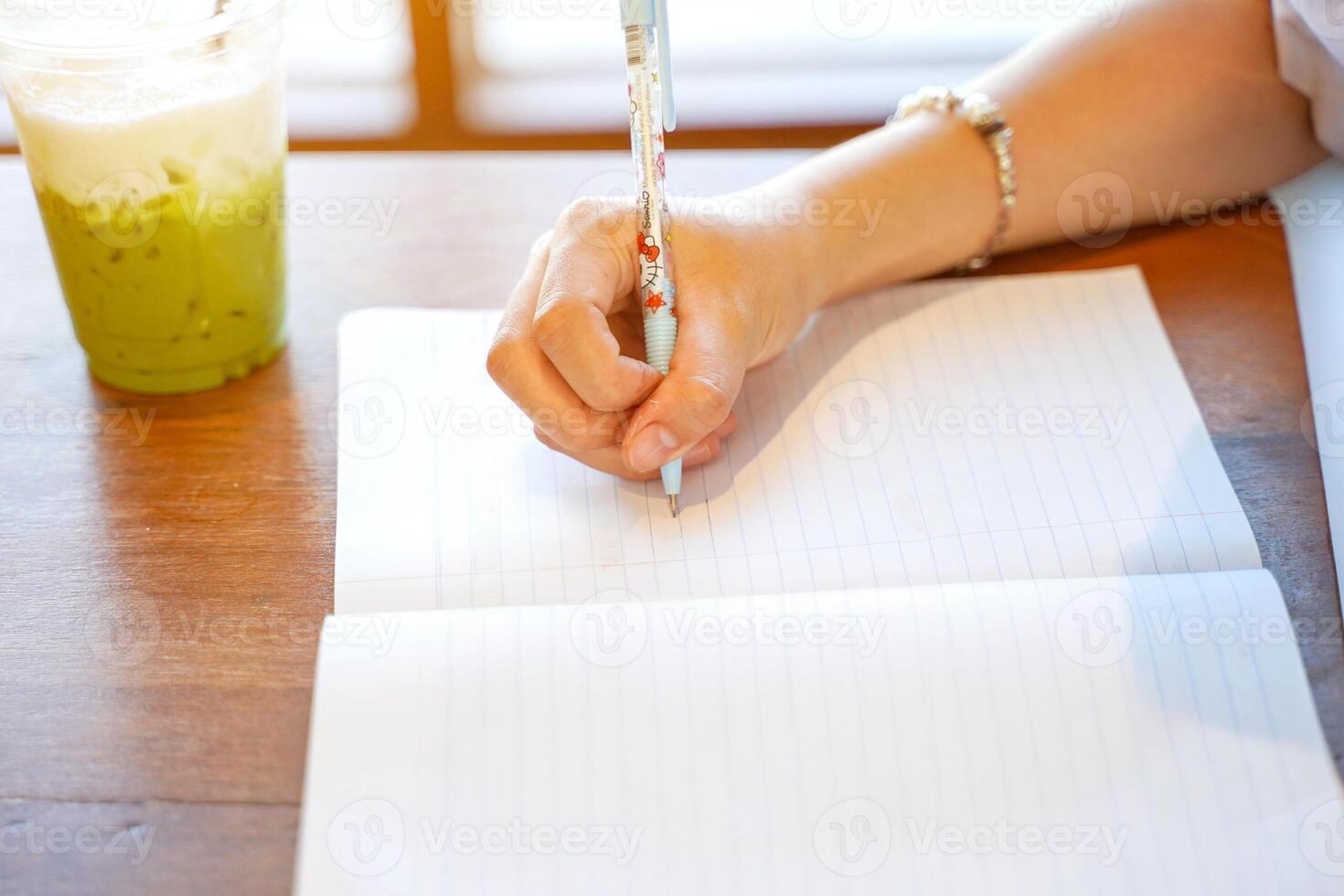 Closeup and crop hands of Thai student studying and make a short note on textbook in class room with sun flare background. Network education concept. photo