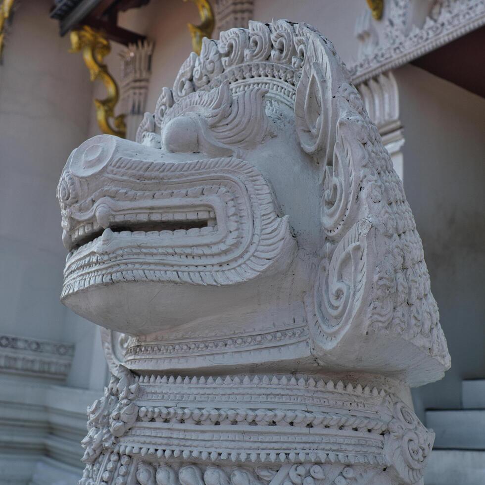 a white lion statue in front of a temple photo