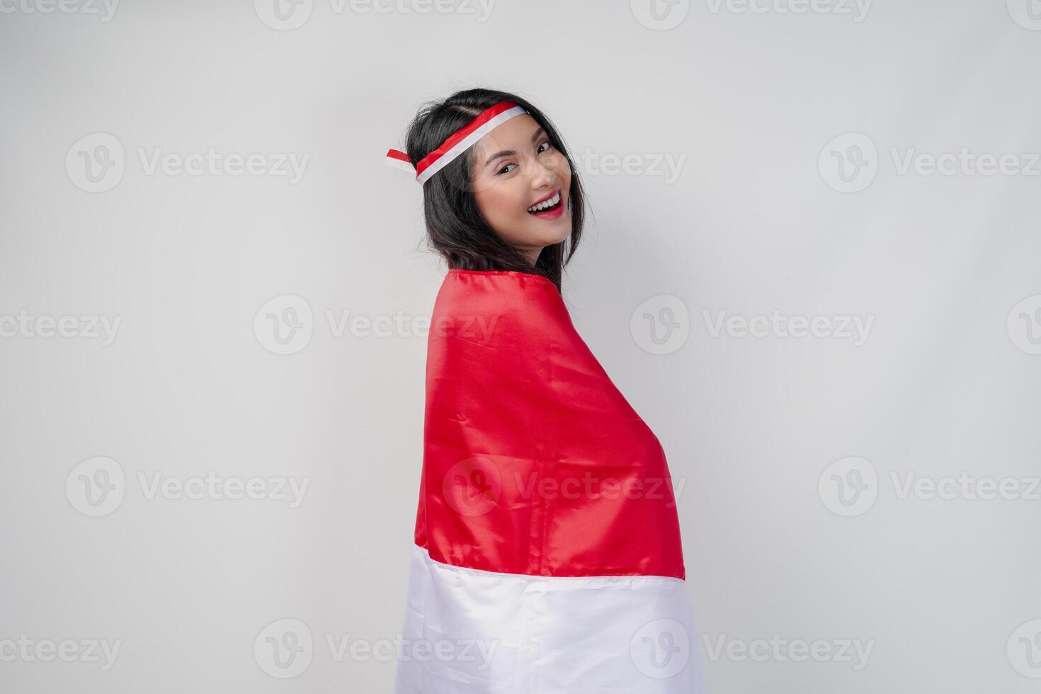 Smiling young Asian woman with Indonesian flag draped over her shoulders. photo