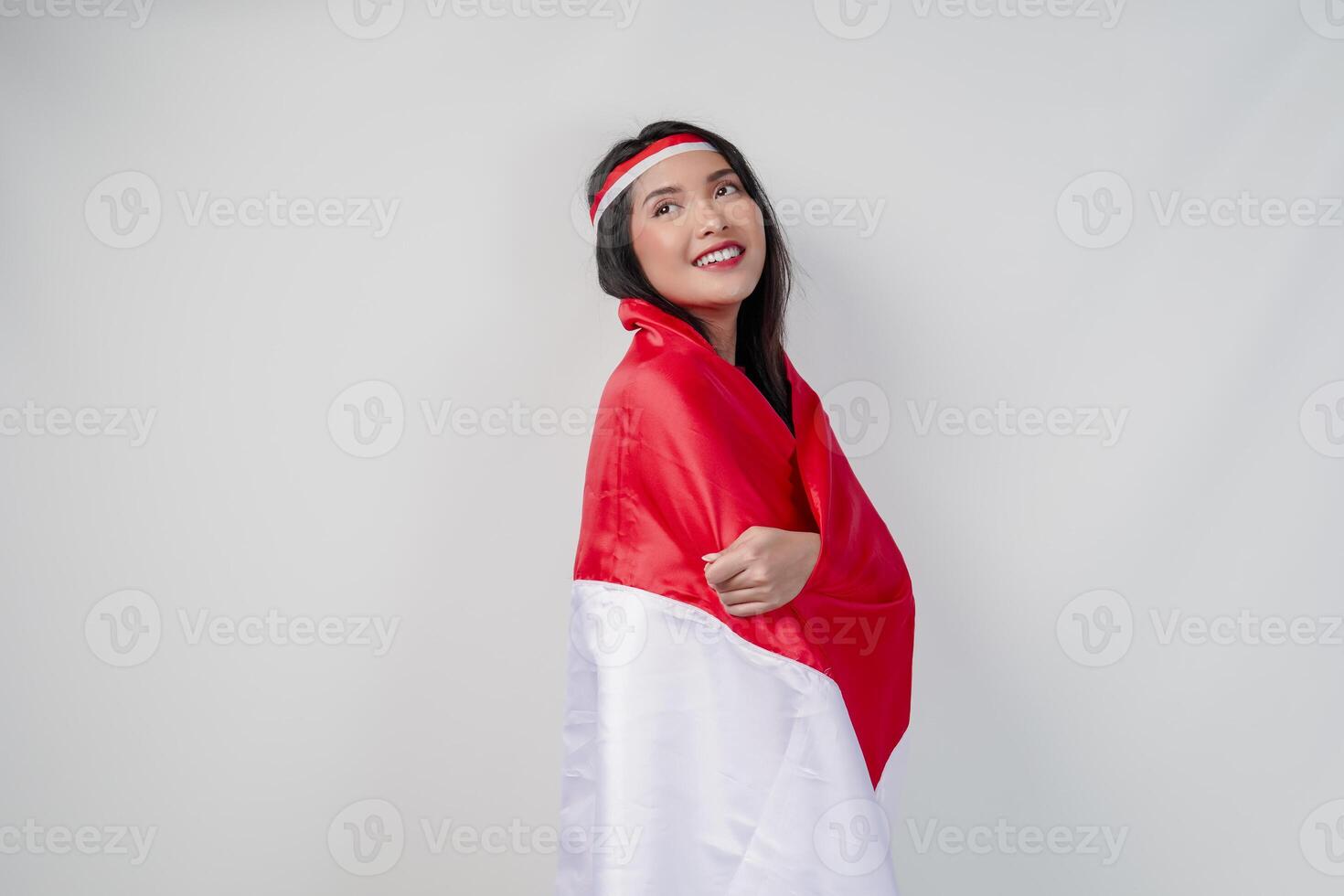 Smiling young Asian woman with Indonesian flag draped over her shoulders. photo