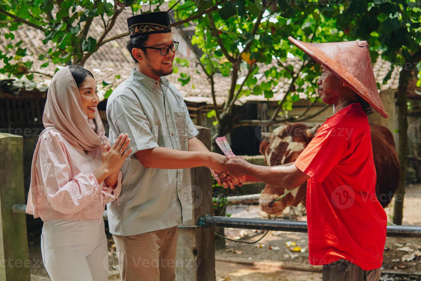 Happy Asian Muslim couple doing handshake with the cattleman buying livestock cows for sacrifices. Eid Al Adha concept. photo