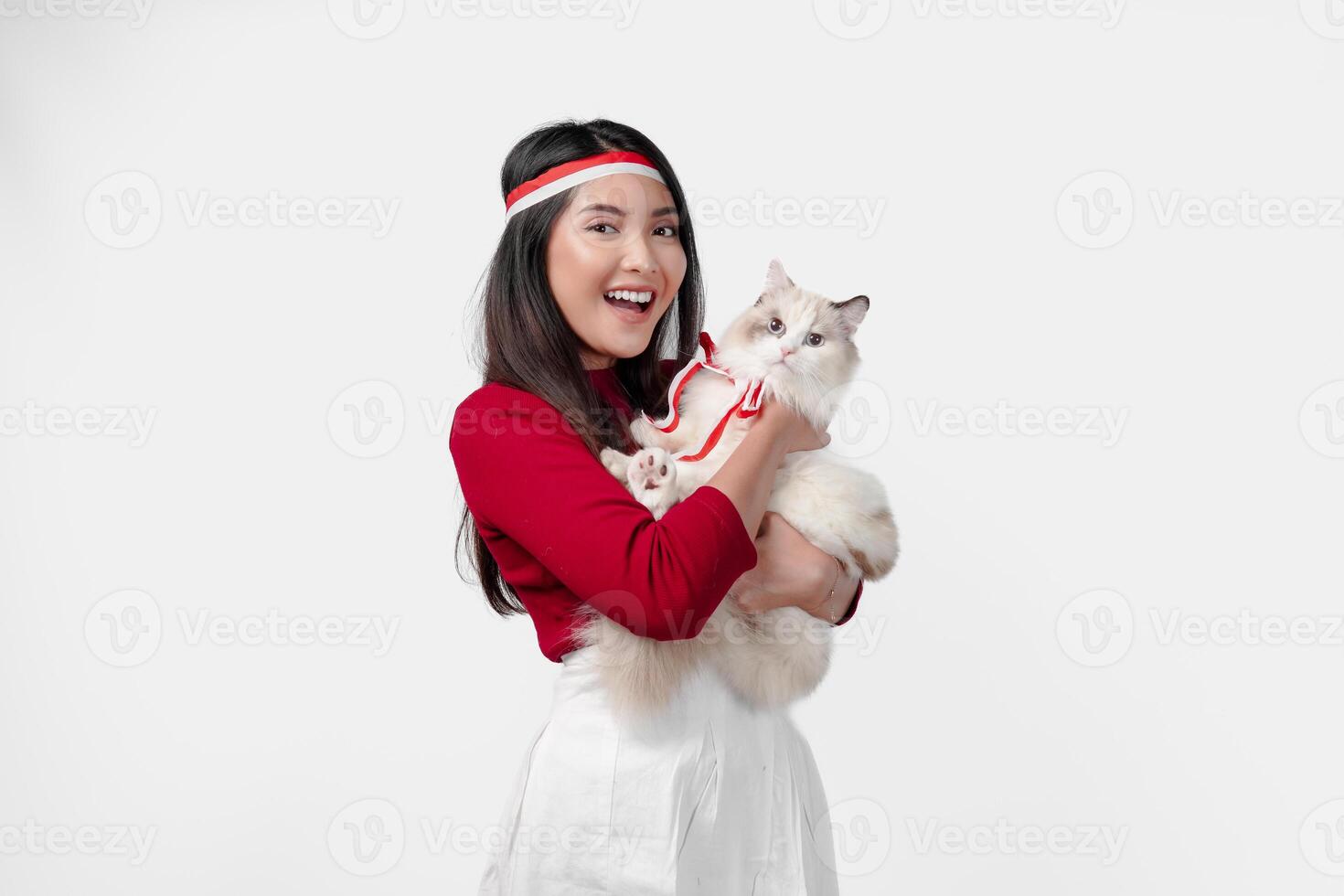 Lovely young Indonesian woman is holding a white ragdoll cat and smiling. photo