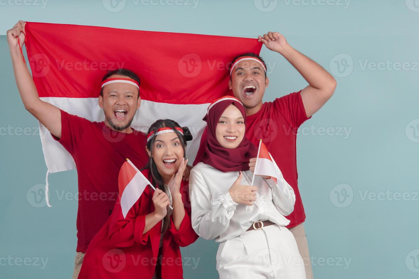 A group of Indonesian people are holding their country flag and smiling to the camera. photo