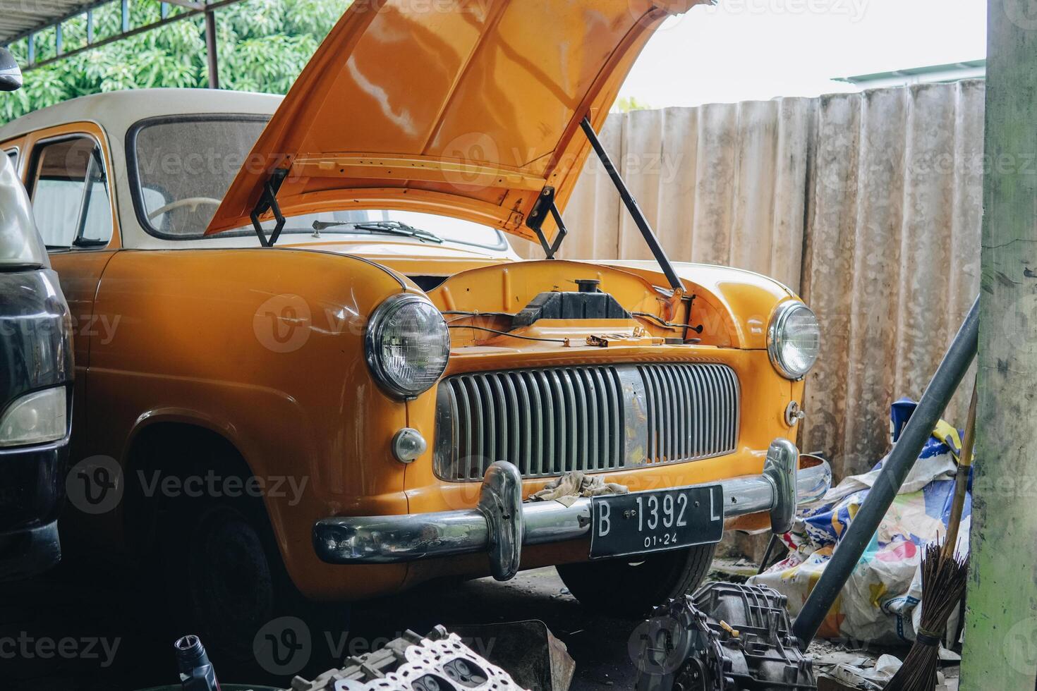 An old orange car with the hood up photo