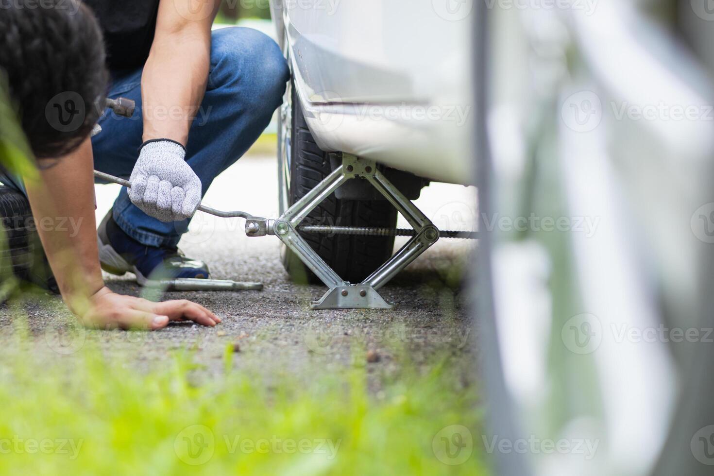 mechanic is preparing the equipment and spare tire to change the tire of the car that had a flat tire during the journey and the mechanic was called by the emergency application of the service center. photo