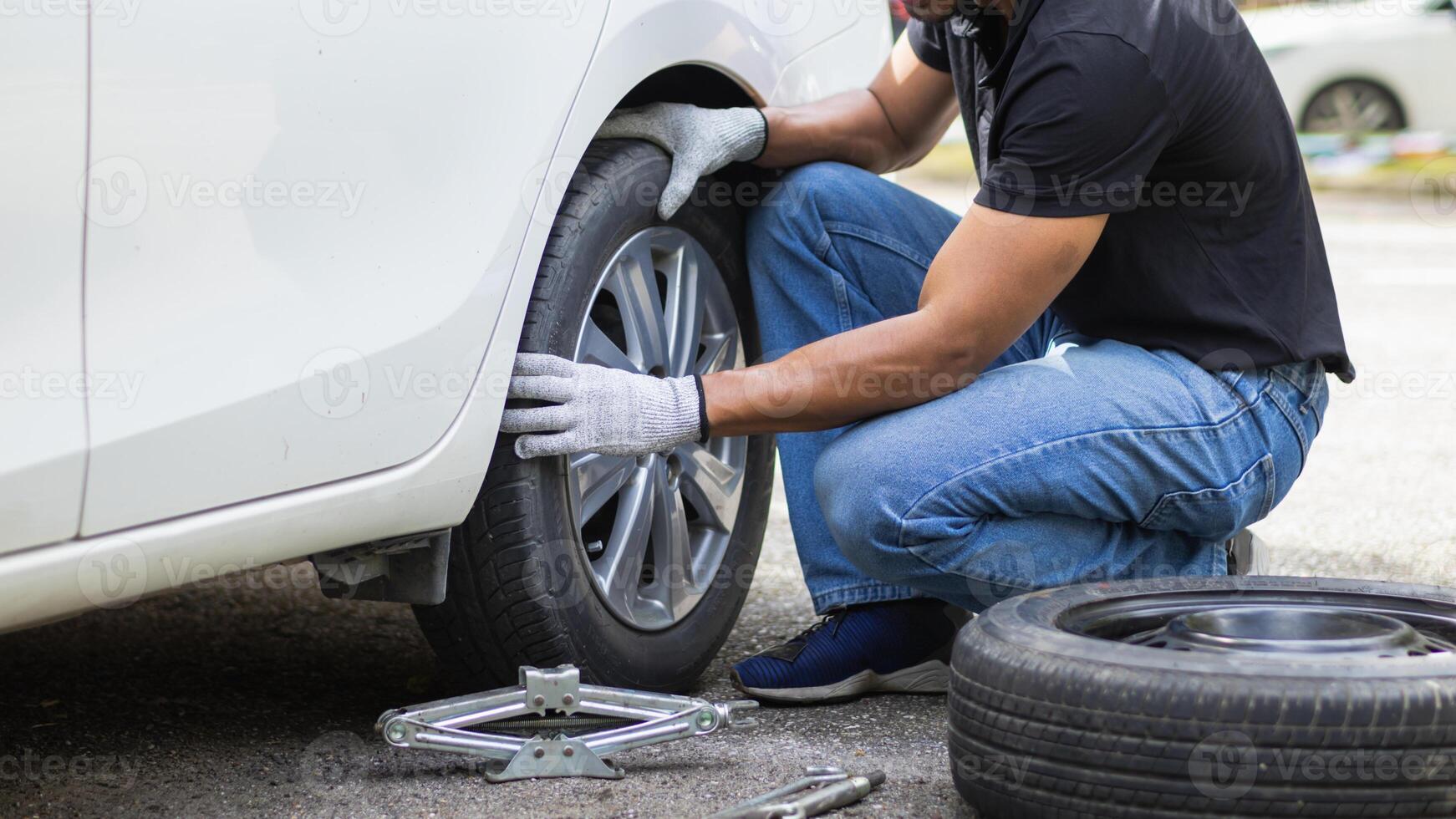 mechanic is preparing the equipment and spare tire to change the tire of the car that had a flat tire during the journey and the mechanic was called by the emergency application of the service center. photo