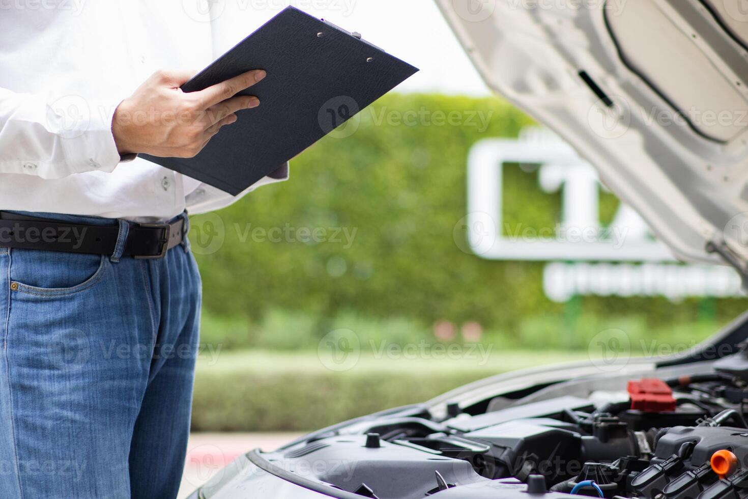 salesman is checking condition of car before delivering it to customer to ensure the quality and service after agreeing to sales contract. concept of checking the condition of the car for confidence photo