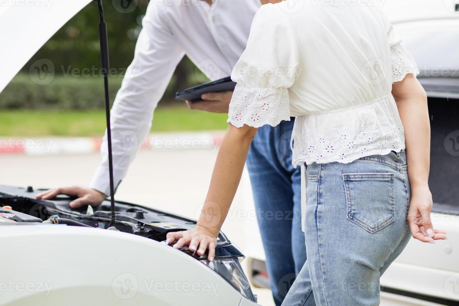 salesman is checking condition of car before delivering it to customer to ensure the quality and service after agreeing to sales contract. concept of checking the condition of the car for confidence photo
