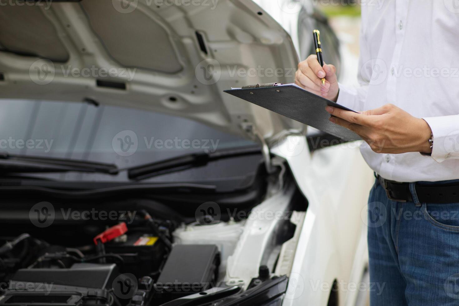 salesman is checking condition of car before delivering it to customer to ensure the quality and service after agreeing to sales contract. concept of checking the condition of the car for confidence photo