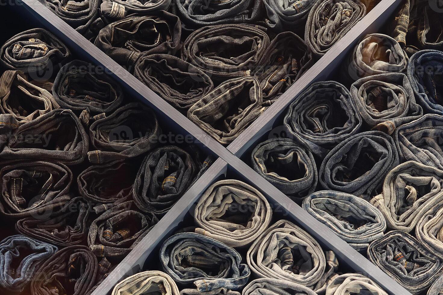A stack of various folded jeans in a clothing store window photo