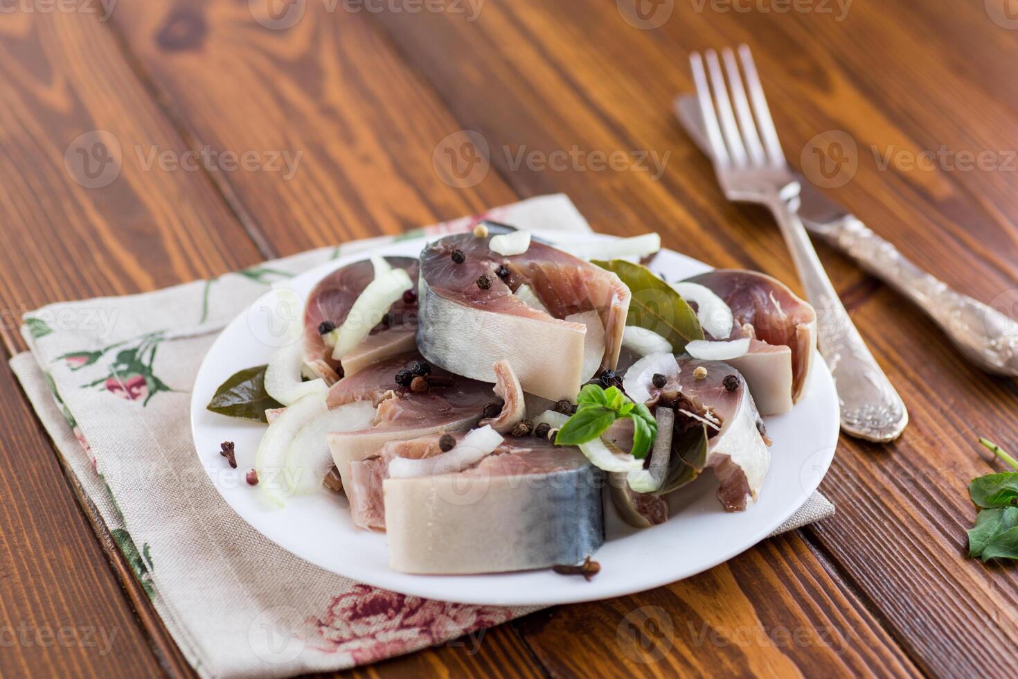 lightly salted mackerel with onions and spices on a wooden table photo