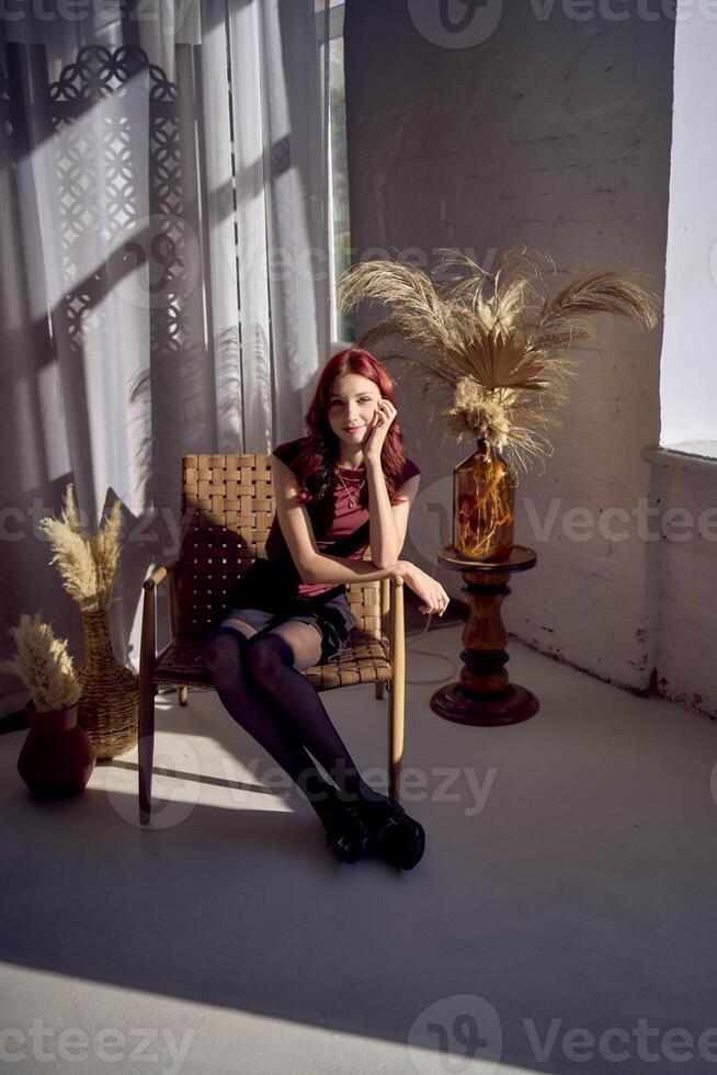 portrait of teenage girl with red hair in interior studio with hard light photo