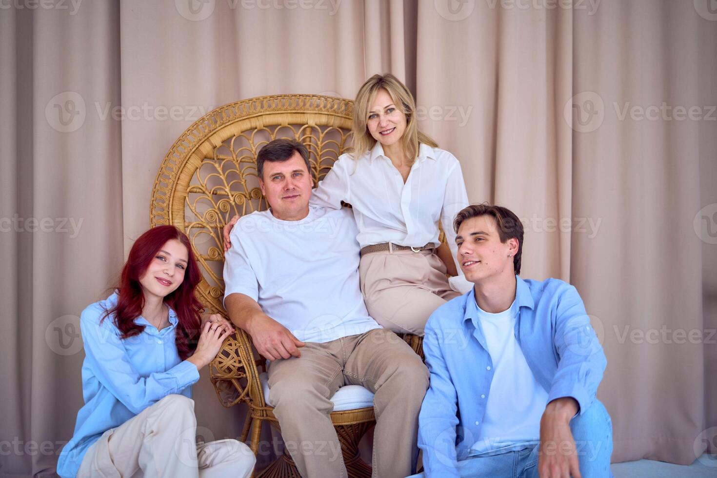 family portrait, middle-aged husband and wife, young adult son and teenage daughter, studio photo shoot