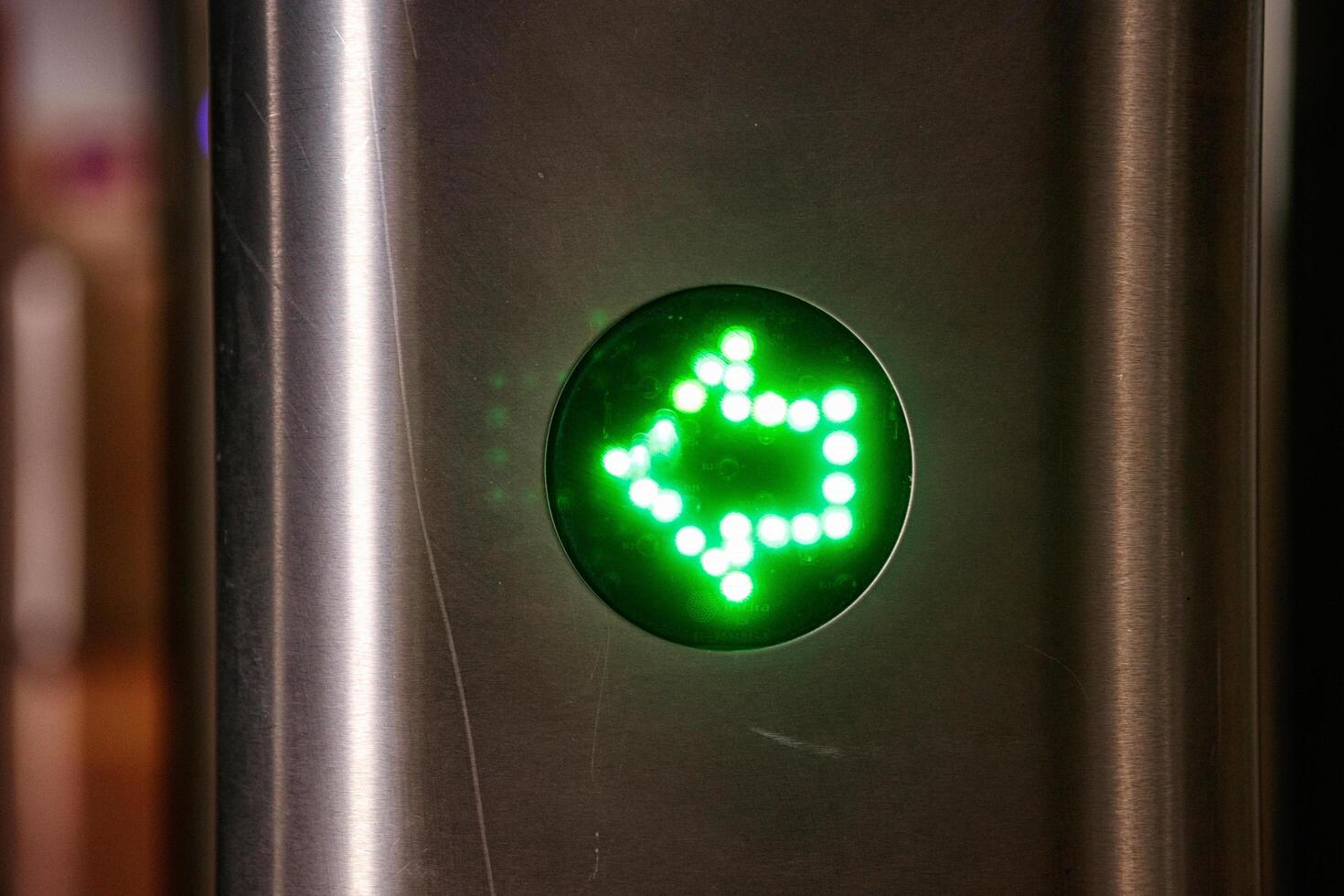 Spain, Valencia, March 29, 2024. Bright Green Directional Light Signaling a Turn at an Urban Transit Station photo