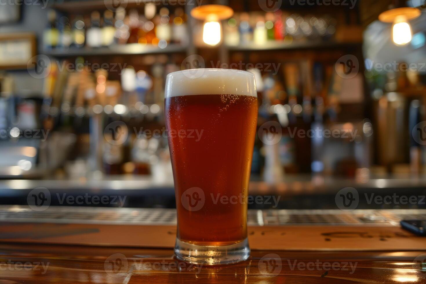 Pint of cold beer standing on bar with blurry background photo