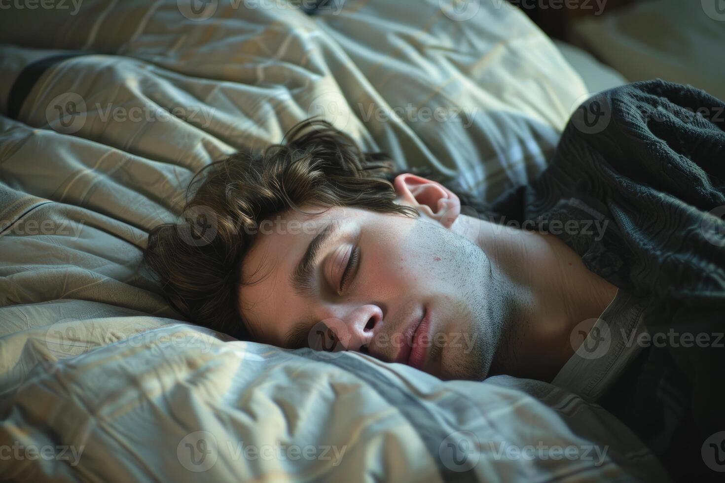 Young man sleeping peacefully in bed on a sunny morning photo