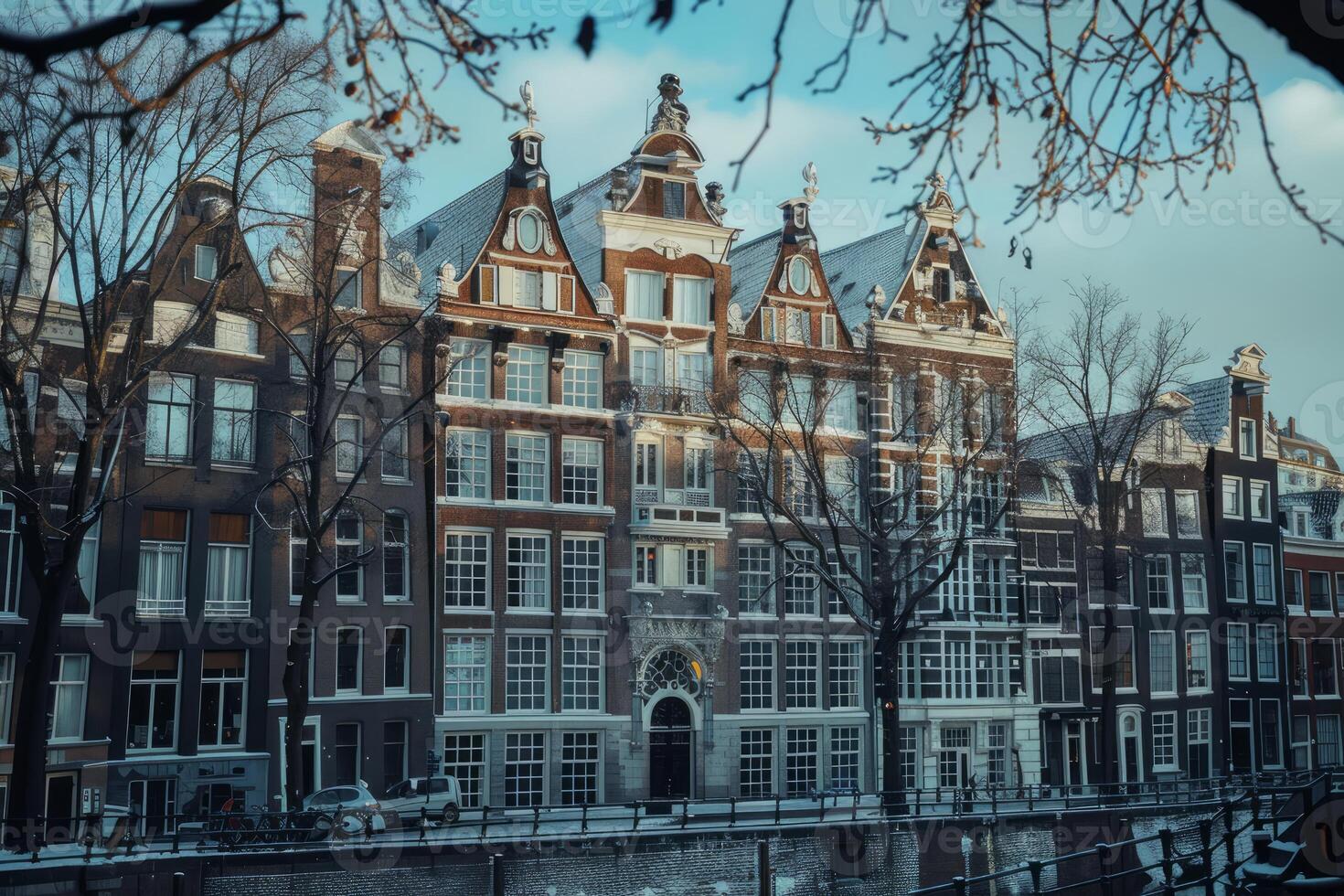 Canal in amsterdam with typical dutch houses covered in snow during winter photo