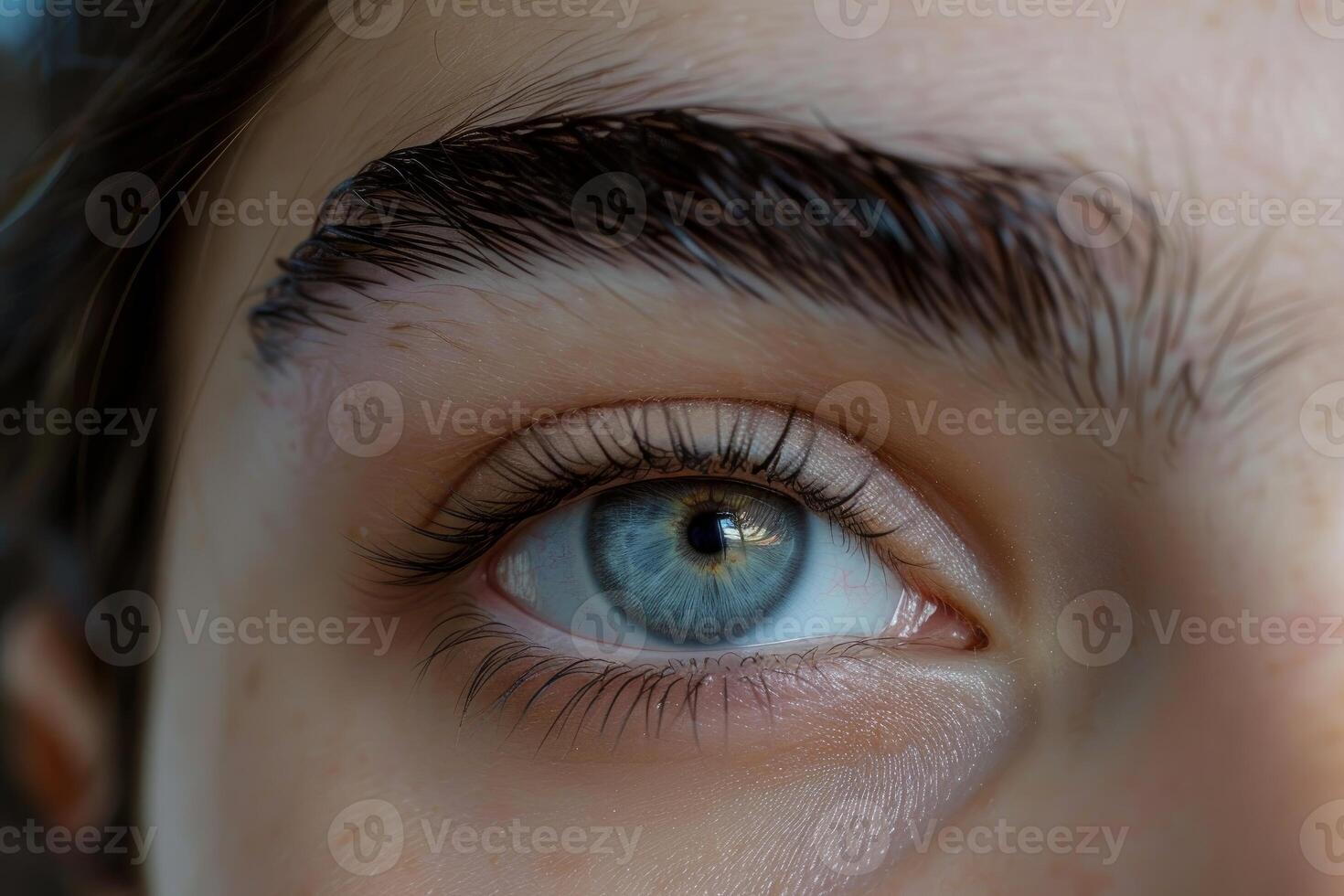 Woman with blue eye showing long eyelashes and perfect eyebrow shape photo