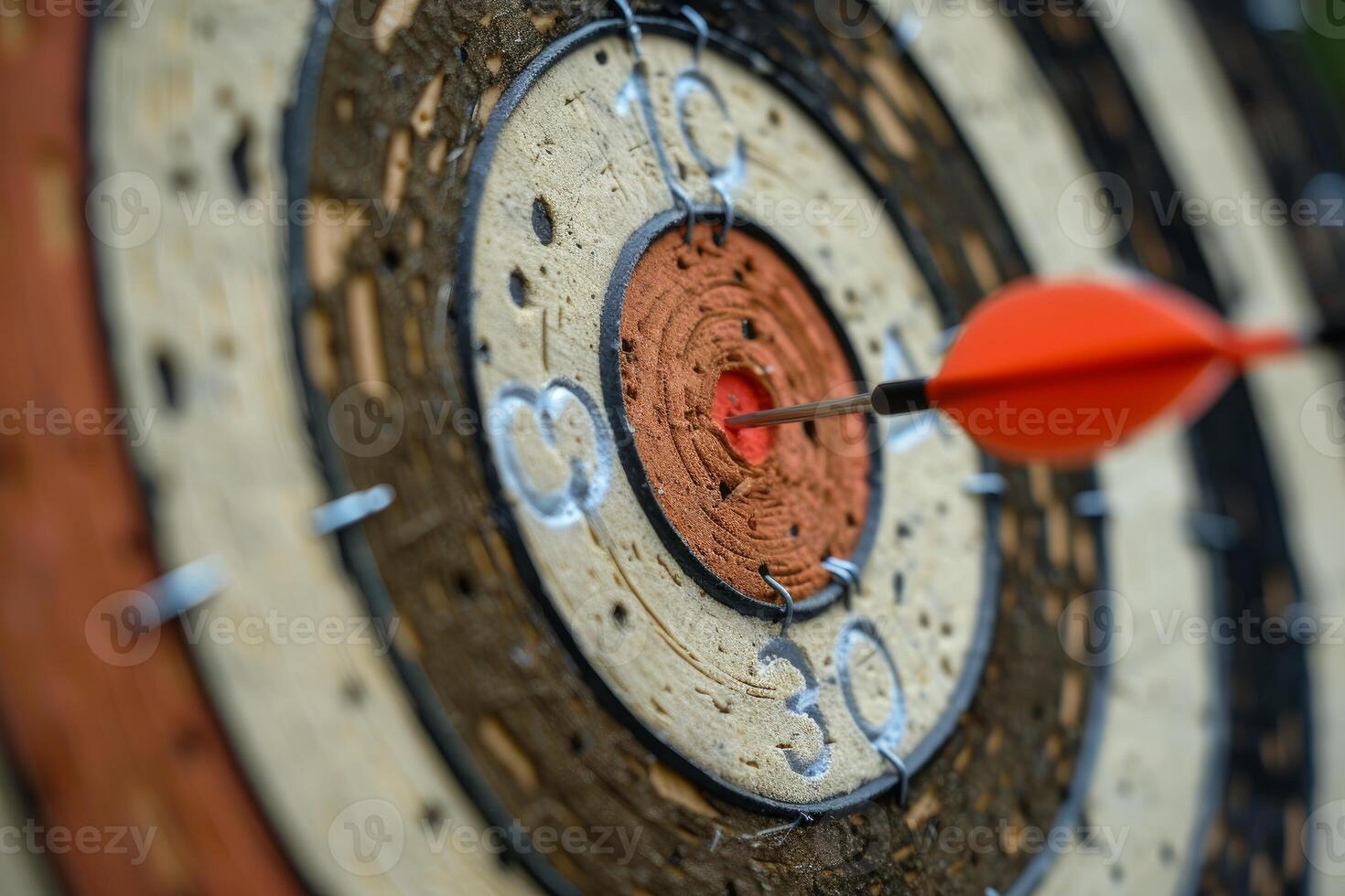 Red arrow hitting the center of an old target on a sunny day photo