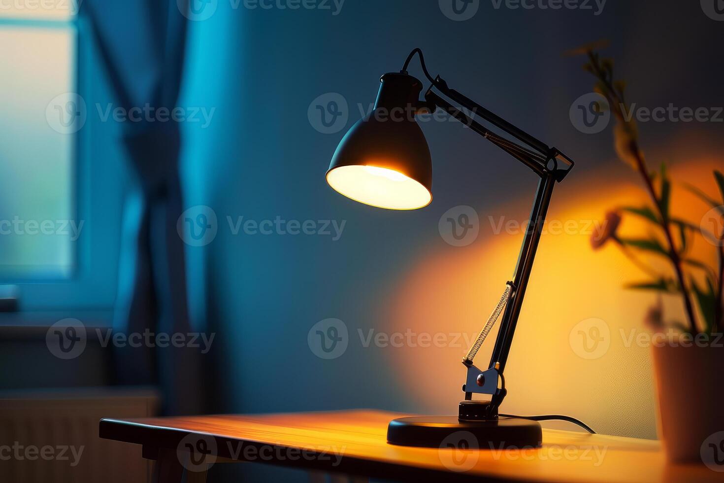 Modern desk lamp illuminating empty desk in room at night photo