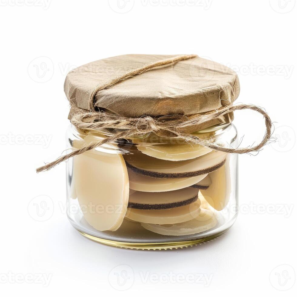 Glass jar filled with white chocolate confectionery covered with brown paper and tied with string photo
