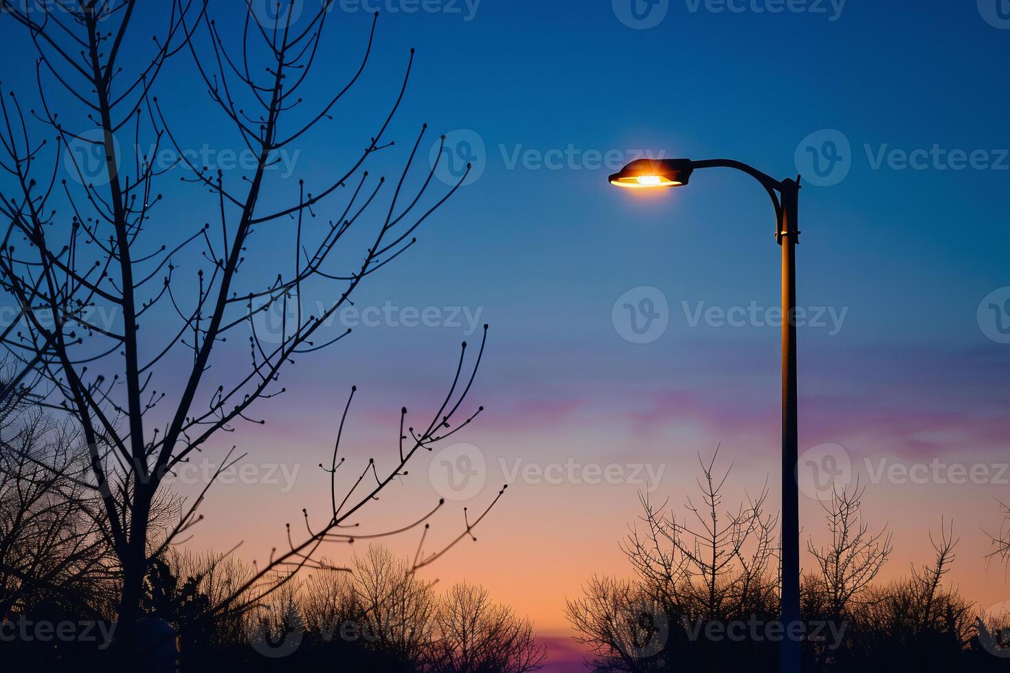 Street light turning on at dusk with colorful sky photo